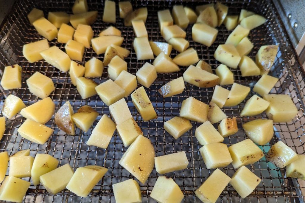 This is diced potatoes in the air fryer basket. 