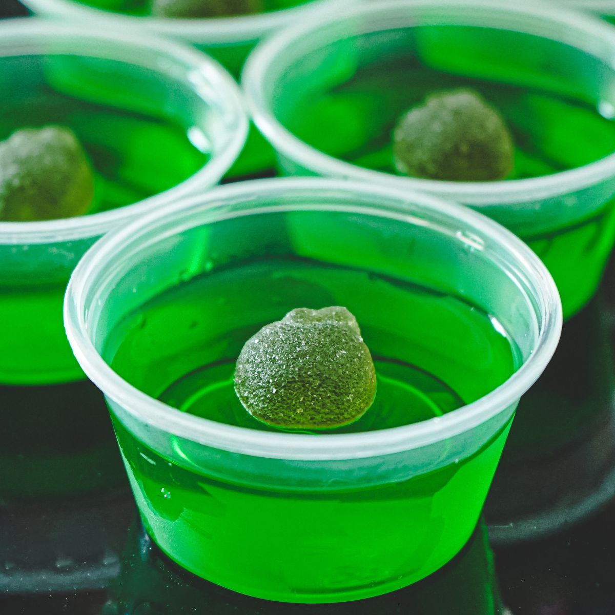This is a closeup of green apple jello shots.